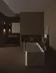 Freistehende Badewanne in modernem Raum mit sanfter Beleuchtung, kombiniert mit einem Chrom-Wanneneinlauf von Ideal Standard. Minimalistisches Design und funktionale Anordnung.
